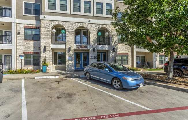 a blue car parked in front of a building