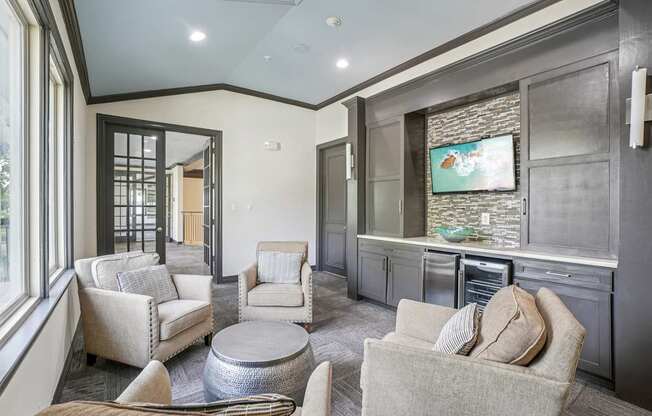 A living room with a grey couch and a television on the wall.