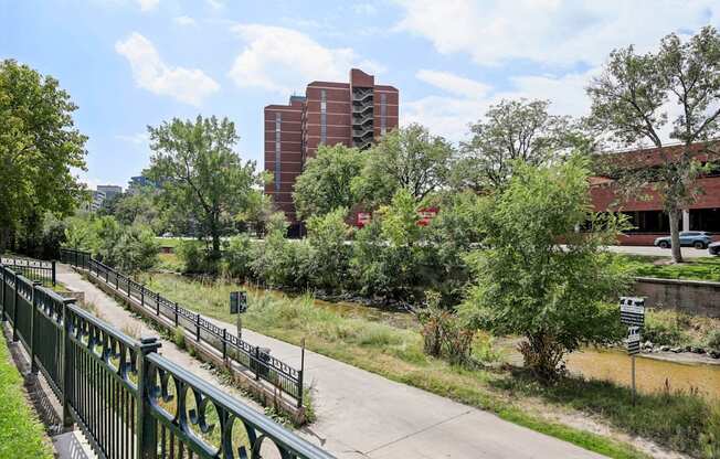 A green fence runs along a concrete walkway.