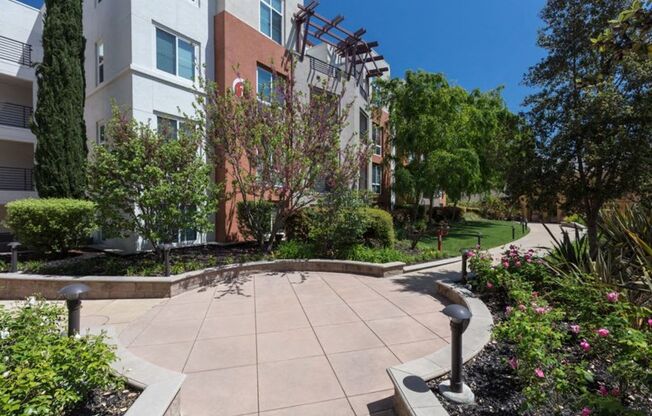 walkway outside apartment building surrounded by greenery