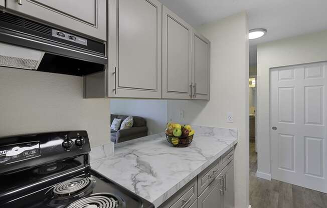 a kitchen with white cabinets and a black stove top oven at Campo Basso Apartment Homes, Washington