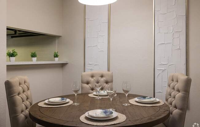 A dining table set with plates and glasses is ready for a meal.