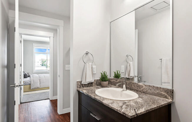Model Bathroom with Wood-Style Flooring and Dark Oak Cabinets at Seven Skies Apartments located in Sandy, UT.