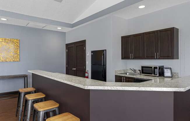 a kitchen with a counter top and a bar with stools