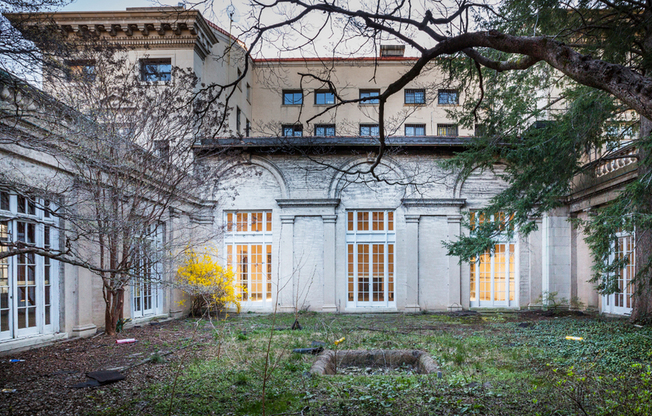 Before: Pre-renovation courtyard featuring original architectural features with gorgeous windows