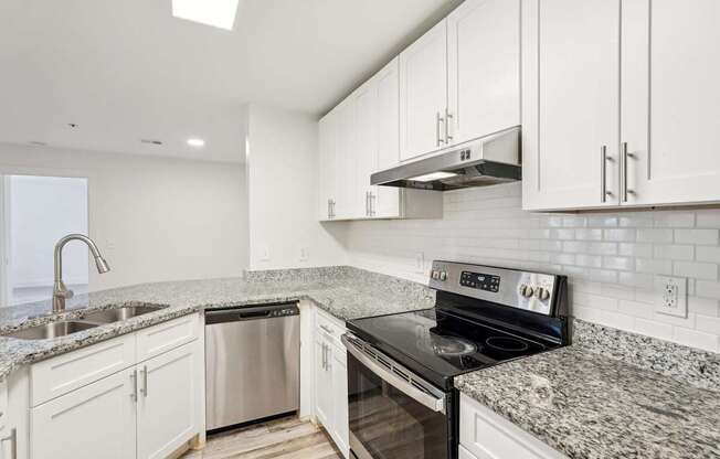 A modern kitchen with granite countertops and stainless steel appliances.