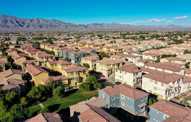 an aerial view of a neighborhood of houses with mountains in the background