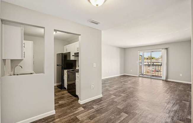 A kitchen with white cabinets and a wooden floor.