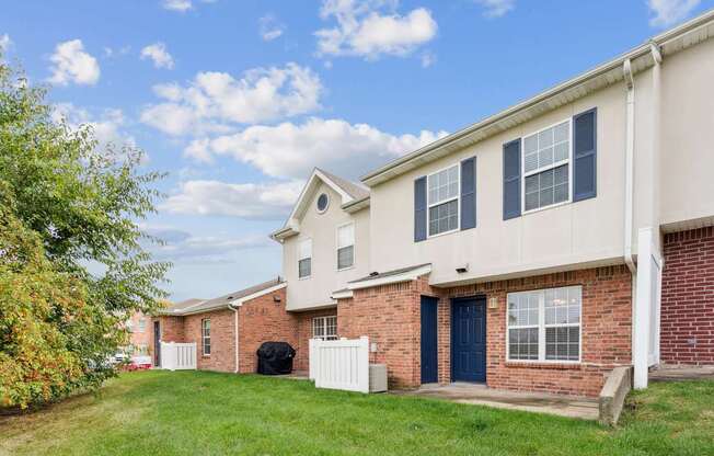 A row of houses with a blue sky and clouds in the background.