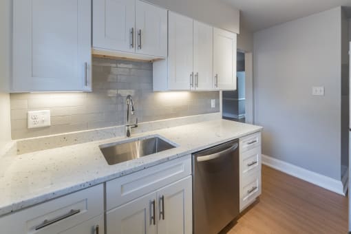 The Cary renovated kitchen with white cabinets, stainless steel appliances and a microwave