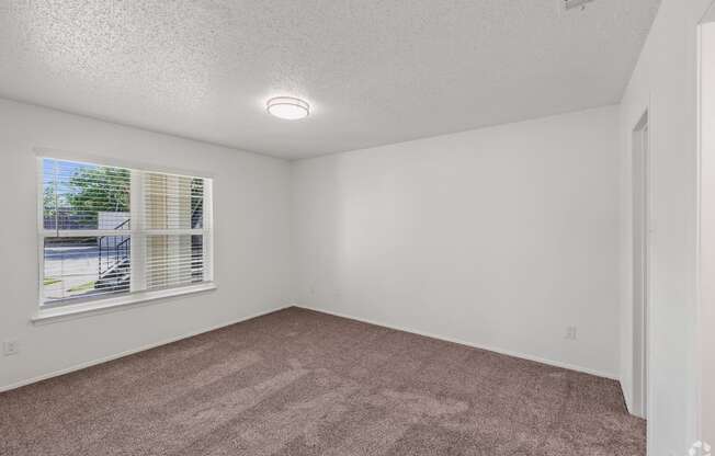 an empty room with carpet and a window