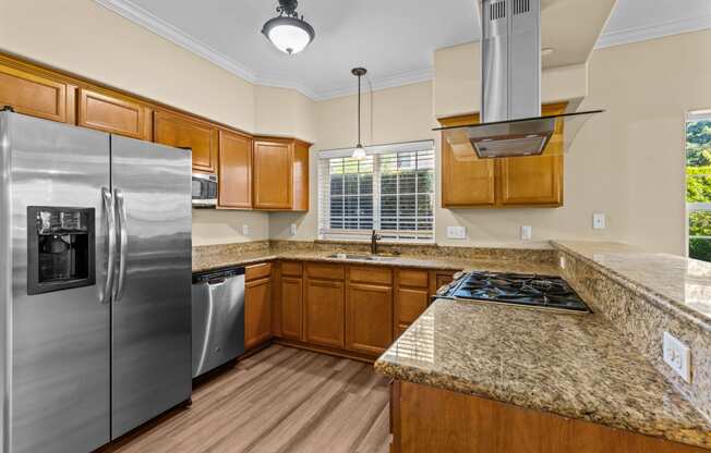 Little Tuscany Apartments & Townhomes - Townhome Kitchen with Stainless Steel Appliances, Granite Countertops, Kitchen Window, Vinyl Plank Wood Flooring, Breakfast Bar
