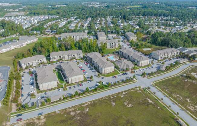 an aerial view of a neighborhood of houses and cars in a parking lot