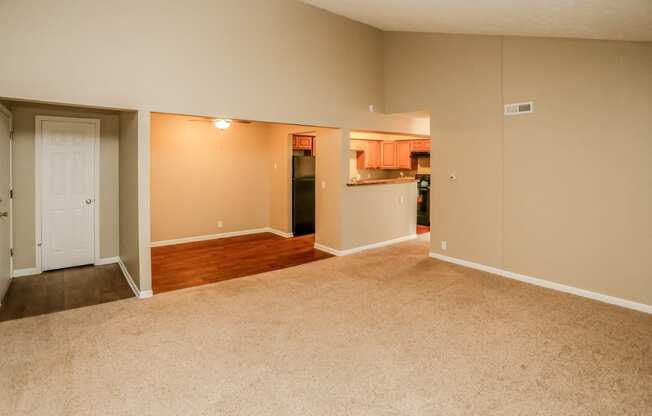 an empty living room and kitchen with wood flooring. Omaha, NE Evergreen Terrace Apartments