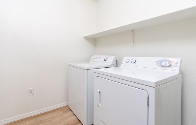 a washer and dryer in a room with a wood floor