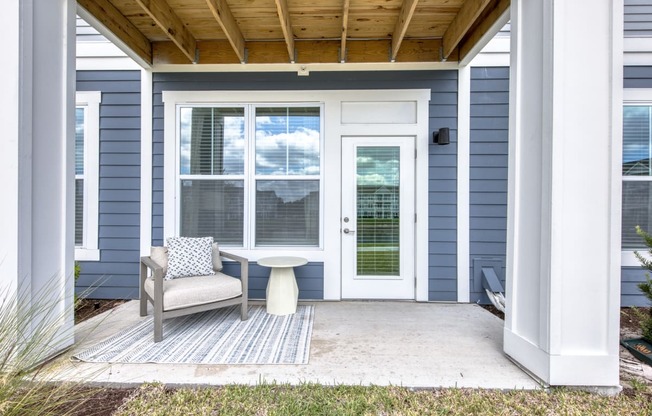 a front porch with a chair and a table on it