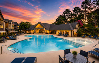 A large outdoor swimming pool surrounded by lounge chairs and a table with a potted plant.