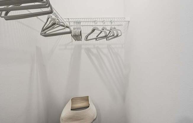 A white chair is under a clothes drying rack.
