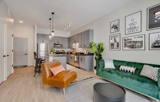 A living room with brown leather chair and a kitchen