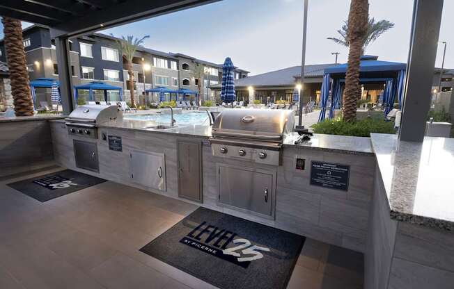A modern outdoor kitchen area with a grill and sink.