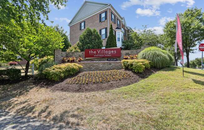 the village sign in front of a brick house