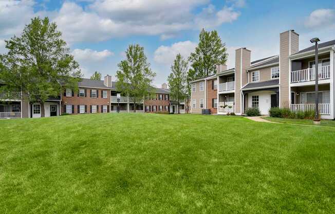 A grassy area in front of apartment buildings.
