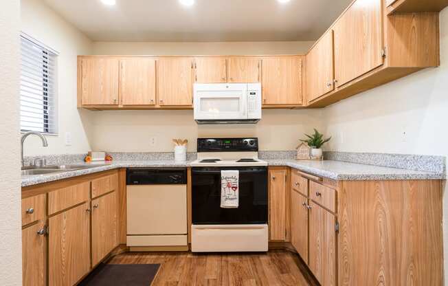 Kitchen with Wooden Cabinets and Granite-Style Countertops at Woodbend, Alta Loma