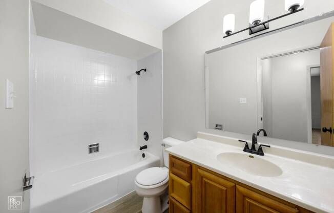 a bathroom with a white tub and sink and a toilet