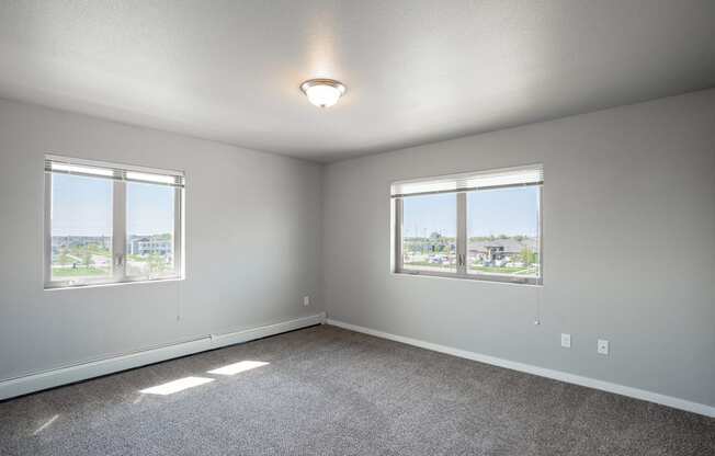 a bedroom with two windows. Fargo, ND 29 West Apartments