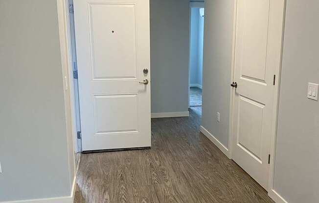 A hallway with two doors and a light on the ceiling.