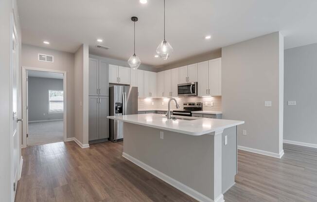 a kitchen with an island and a refrigerator and a sink