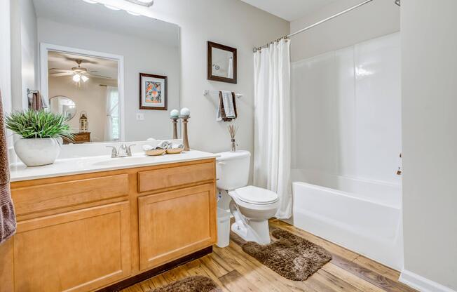 Full bathroom with double vanity, toilet, and garden tub at Westmont Commons apartments for rent