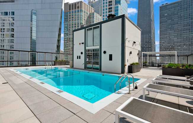 A swimming pool on a rooftop with a building in the background.
