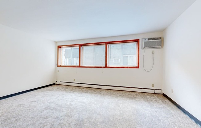 a bedroom with white walls and a large window