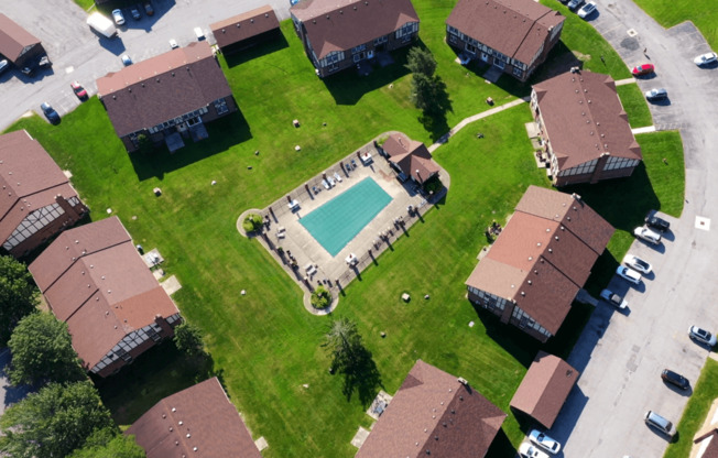 an aerial view of a neighborhood with houses and a swimming pool