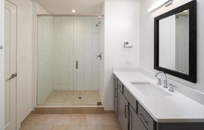 a bathroom with a shower and a sink and a mirror