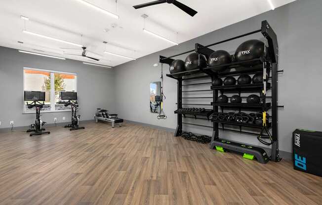 A gym with wooden floors and a variety of exercise equipment.