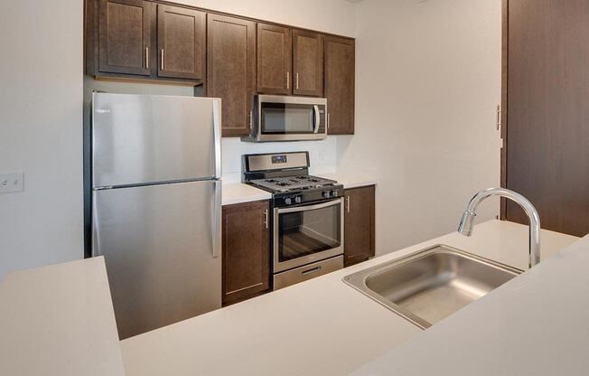 a kitchen with a sink stove refrigerator and microwave