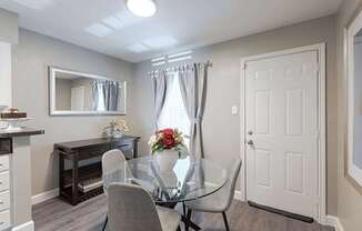 A dining room with a glass table and chairs.