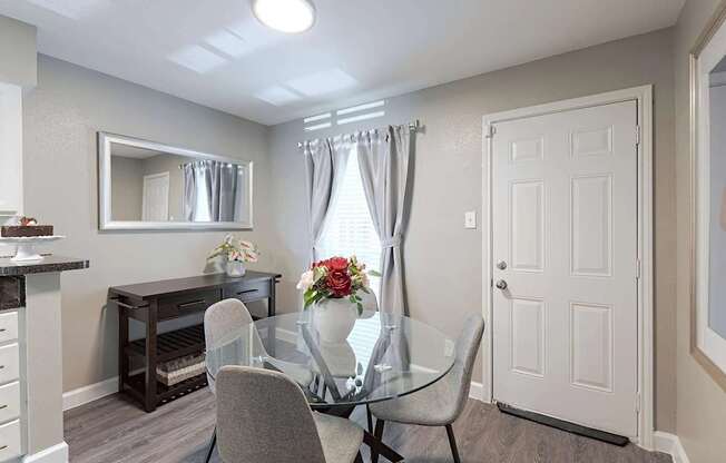 A dining room with a glass table and chairs.