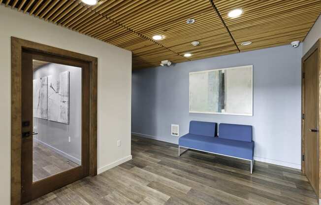 Resident Lobby Area with a blue couch and a large painting on the wall at Excalibur Apartment Homes, Washington, 98004