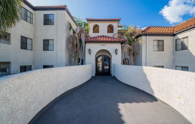 the front entrance of a building with palm trees