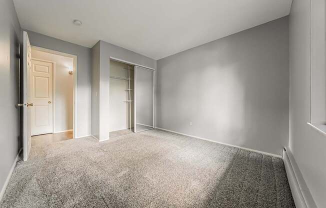 A room with a carpeted floor and two doors.