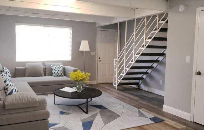 a living room with a couch and a staircase