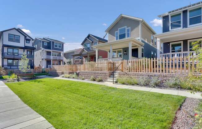 a row of houses with a yard and a sidewalk