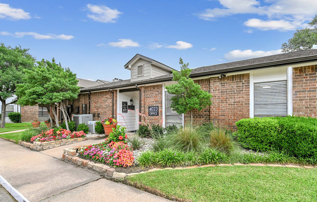 A house numbered 7023 has a driveway and a well-kept lawn.