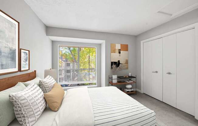 A bedroom with a large bed and a window with blinds.