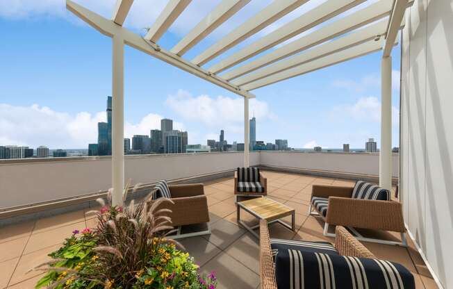 a pergola on a roof terrace with a view of the city in the background