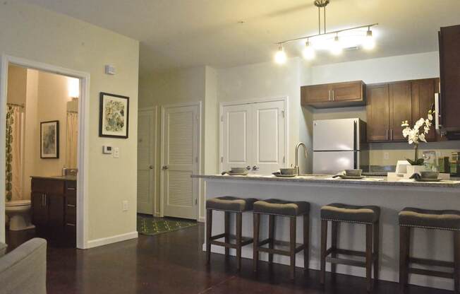 A kitchen with a bar area and a refrigerator.