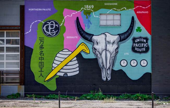 A mural on a wall with a skull and a pencil in the center.